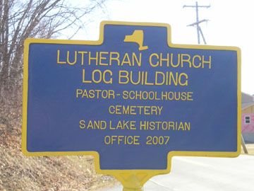Historical marker for Lutheran Church log building in West Sand Lake.