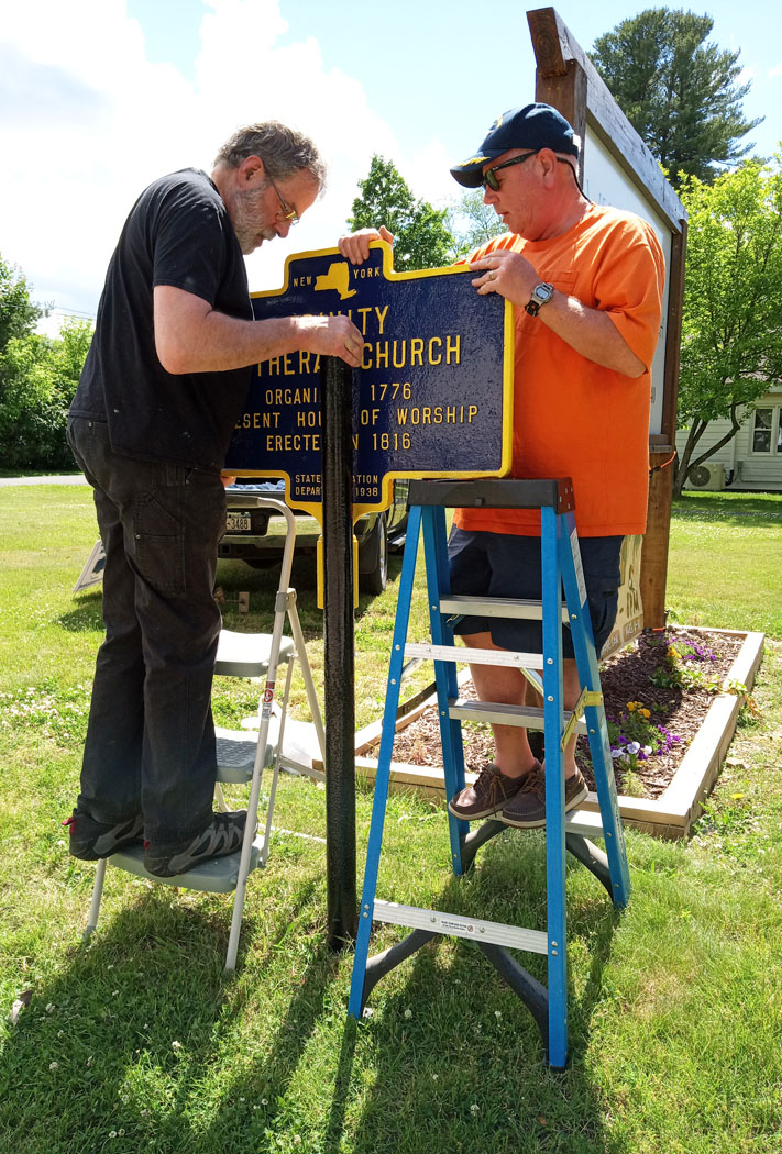 Bud and Mike wrestle the cast-iron marker into place